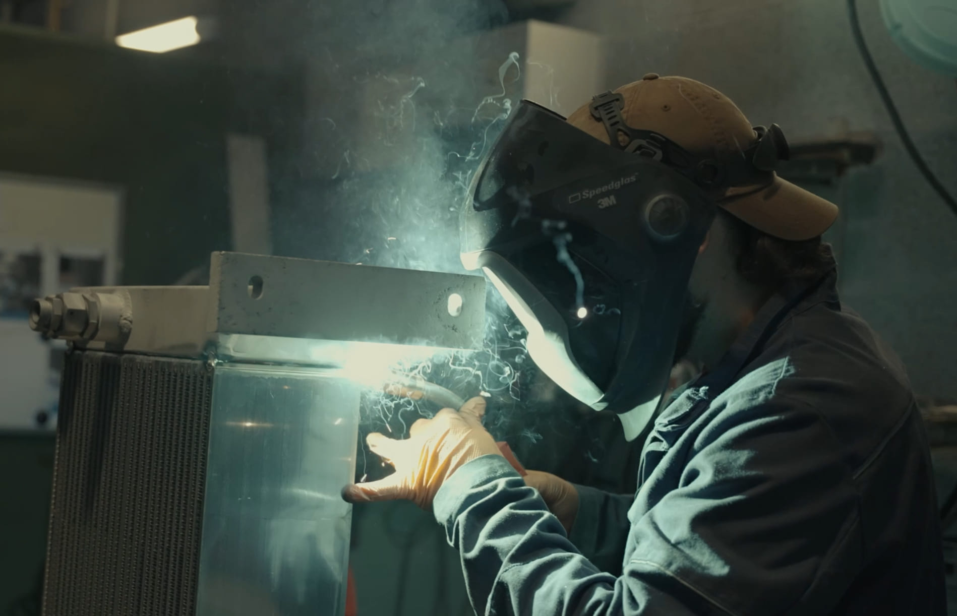 Soudeur au travail, étincelles et masque de protection — film corporate industriel