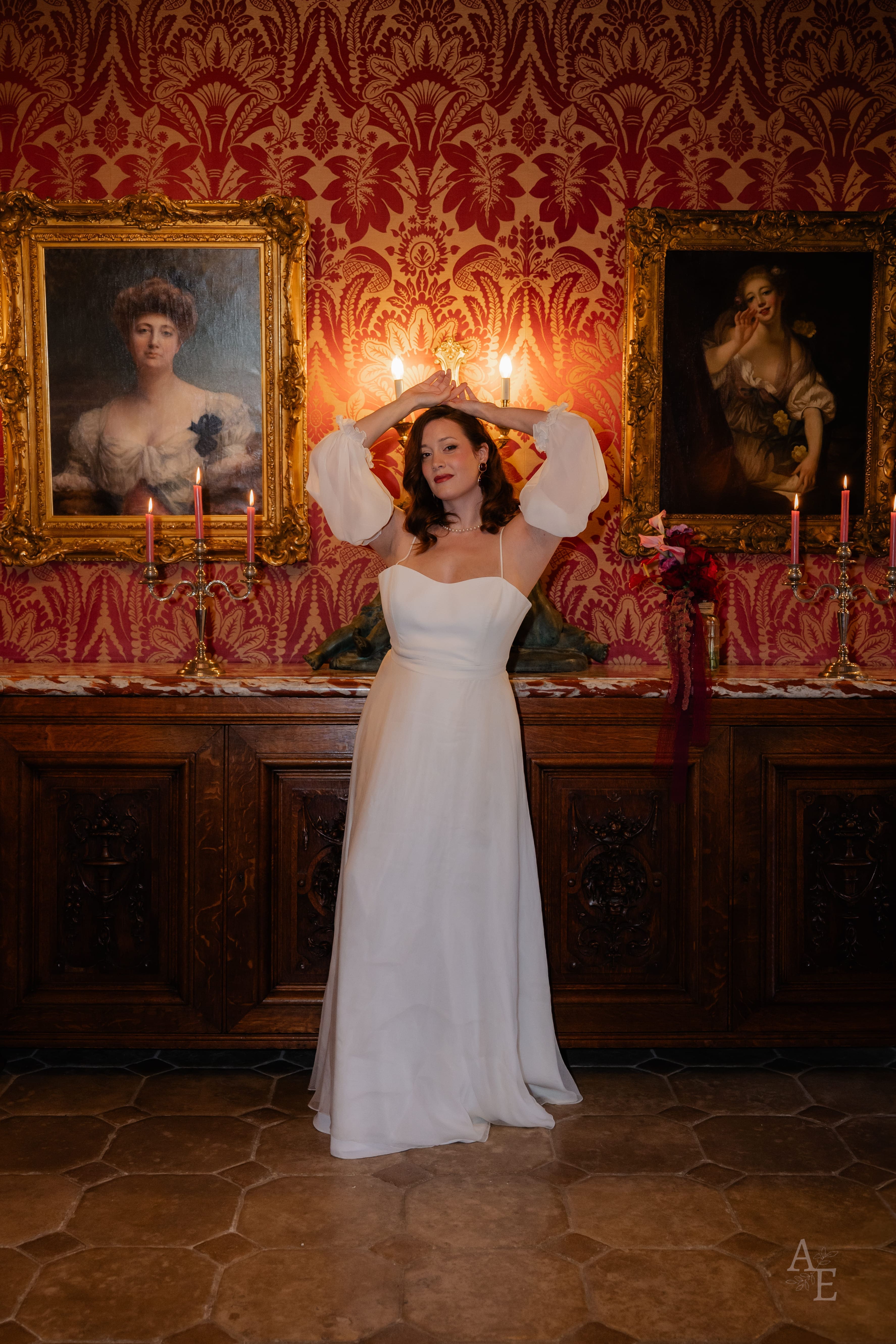 Mariée en robe blanche dans un salon baroque aux portraits anciens et bougies — film de mariage cinématographique